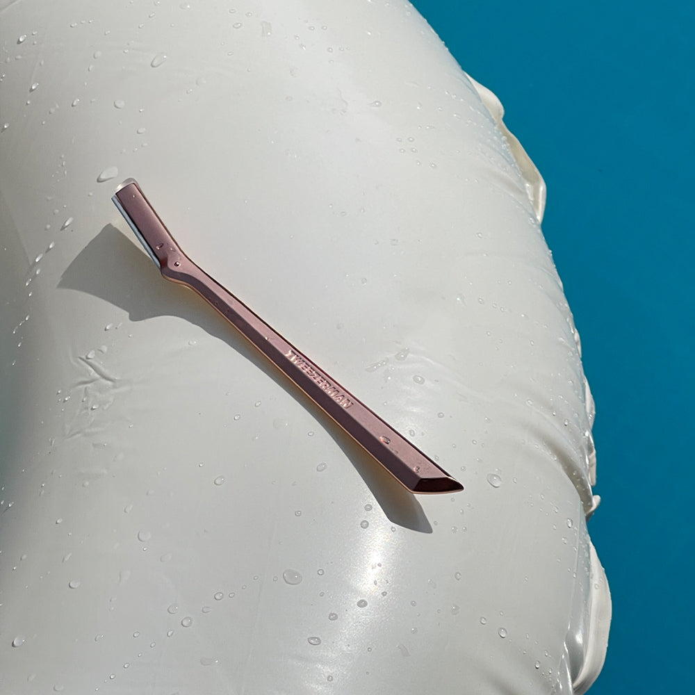 The Rose Gold Facial Razor on a rubber ring  in the pool