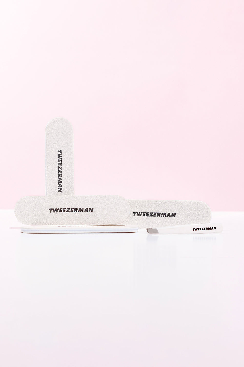 Tweezer an nail set with 'Tweezerman' branding on a light pink background