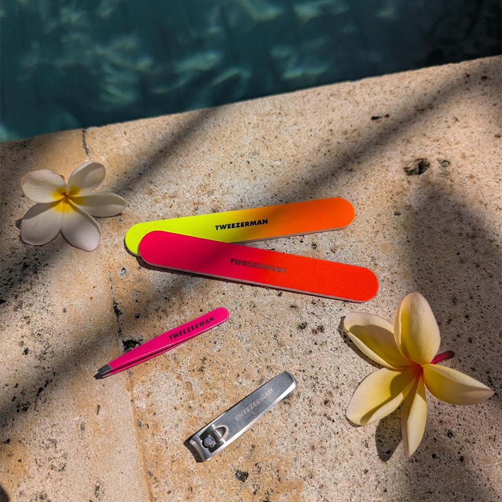 Neon Files, Pink Mini Slant Tweezer and a clipper on the side of a pool with flowers