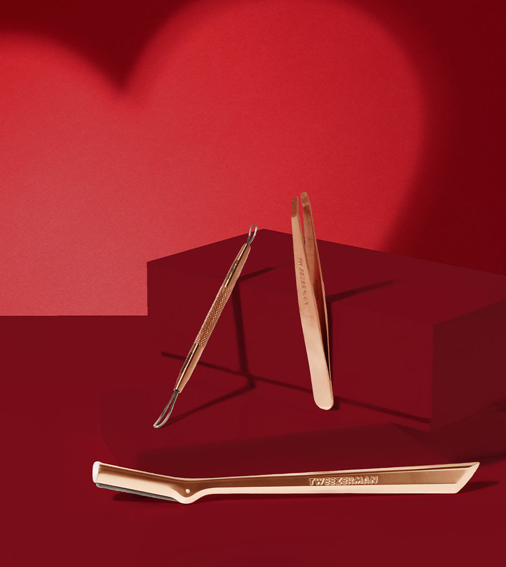 Valentine's design with rose gold beauty tools on red background