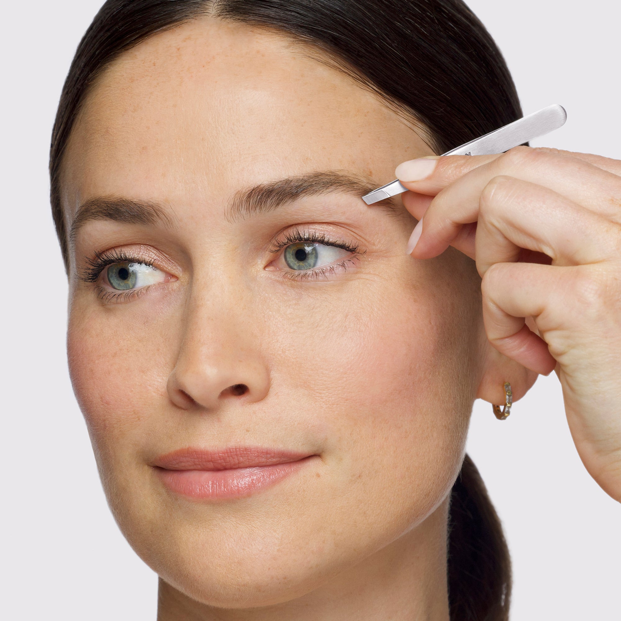 Model using Brow &amp; Facial Grooming Set's Slant Tweezer,