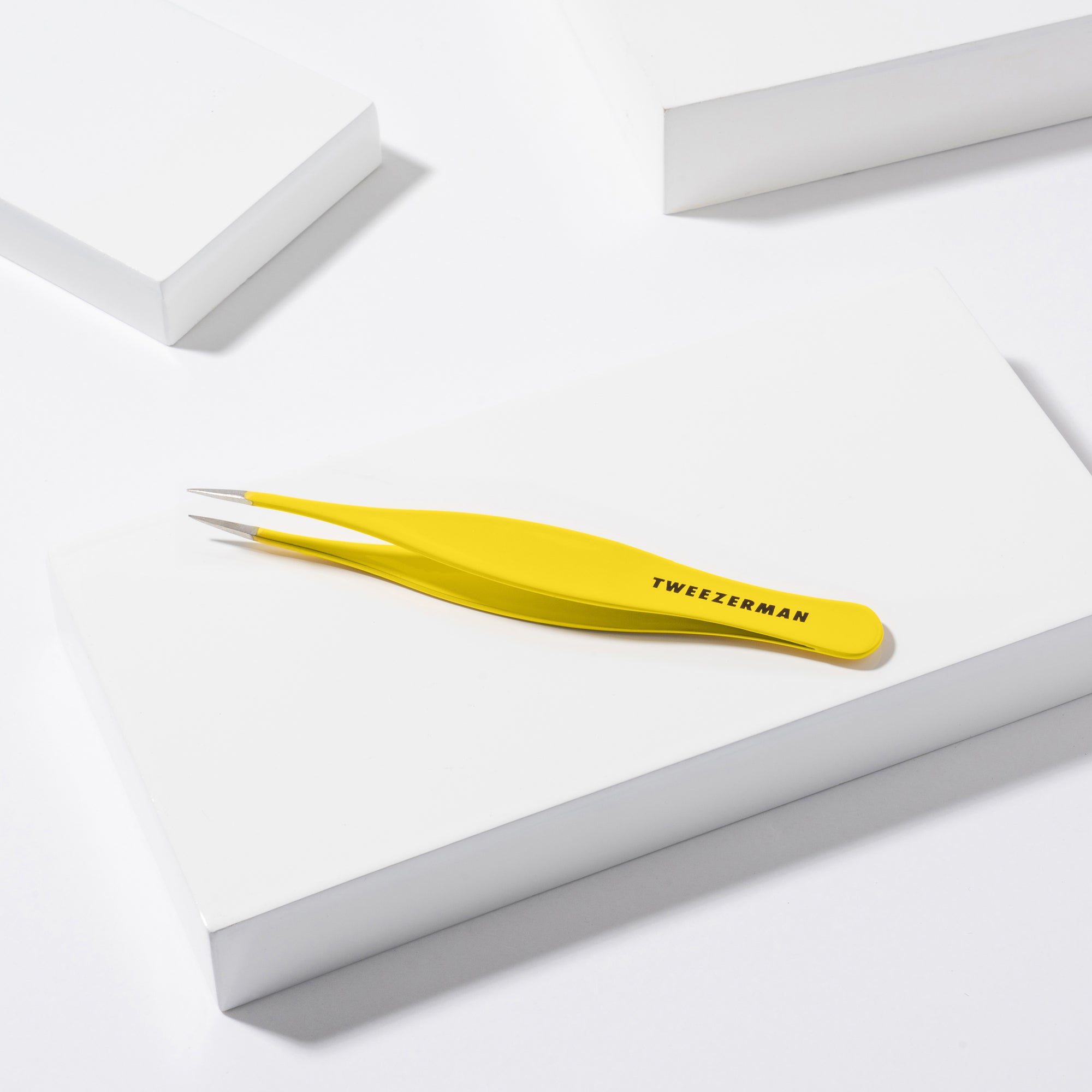 Yellow splinter tweezers with 'Tweezerman' branding on a white background