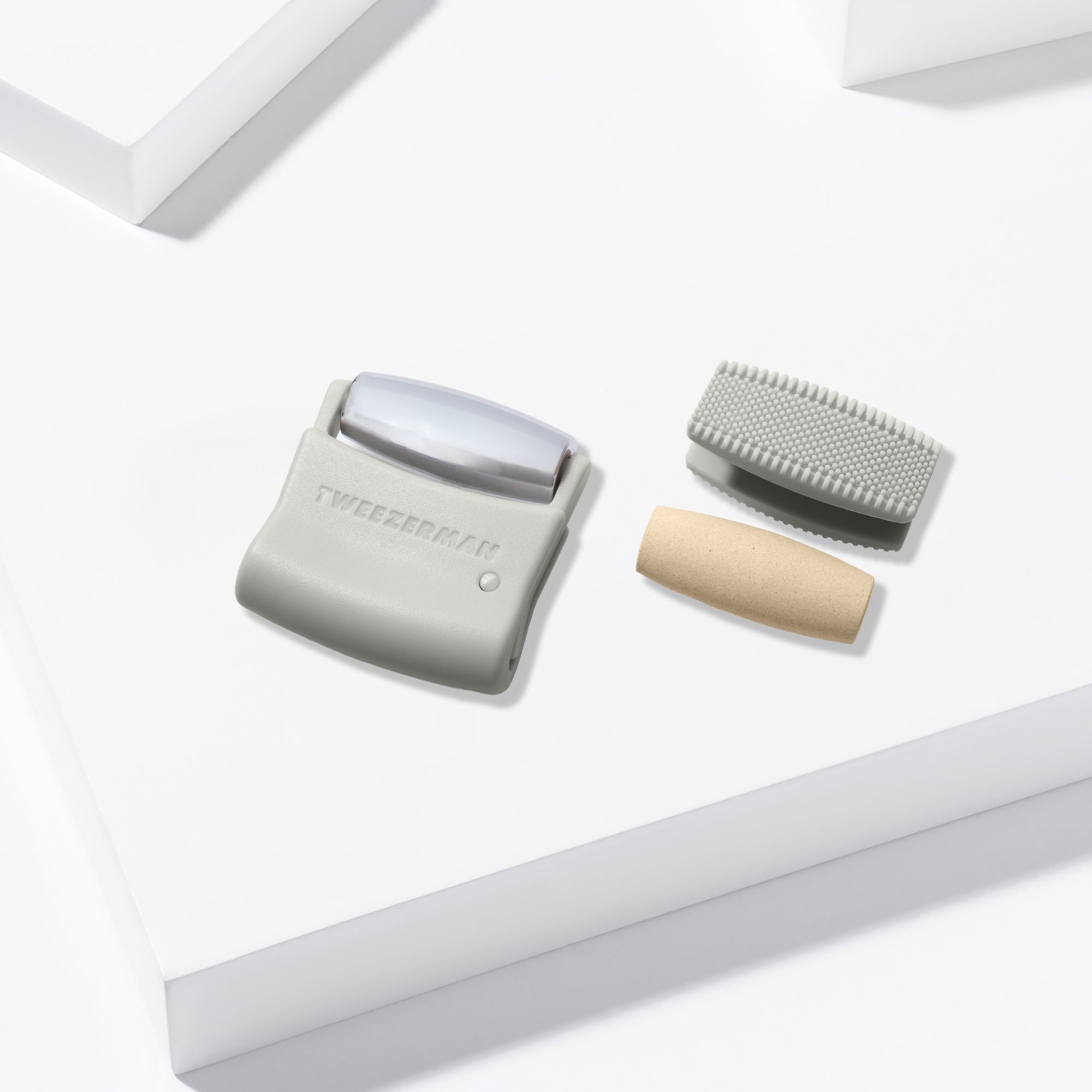 The 3 heads of the facial roller on a white block background