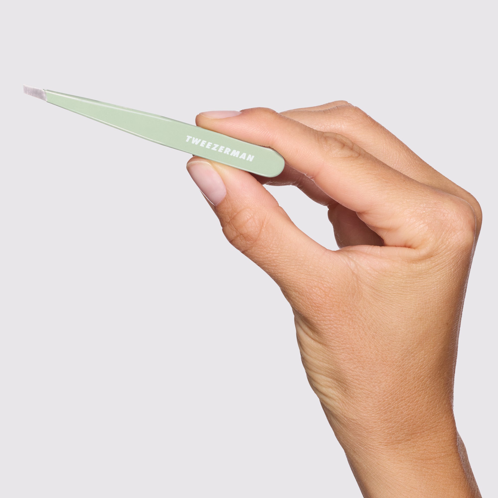 Close-up shot of Model holding Pistachio Full Slant Tweezer