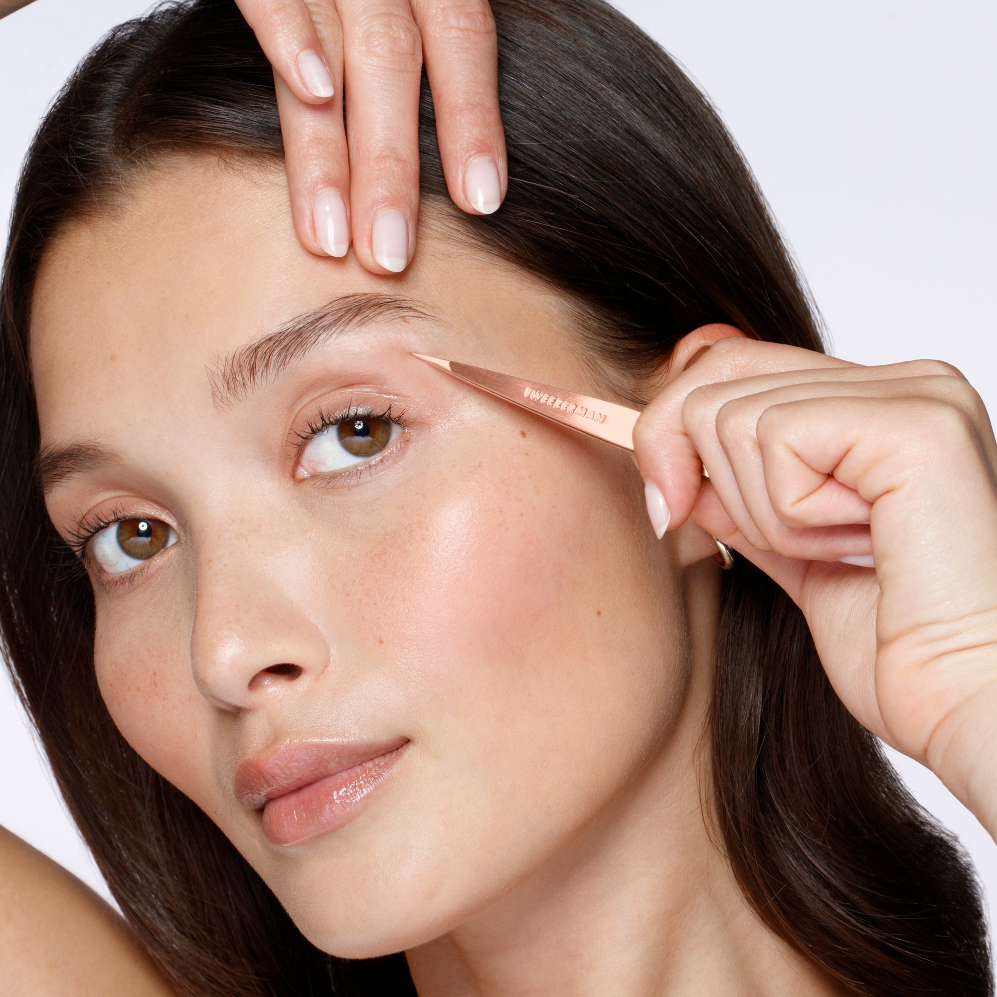 Model using the Rose Gold Point Tweezer on her brows