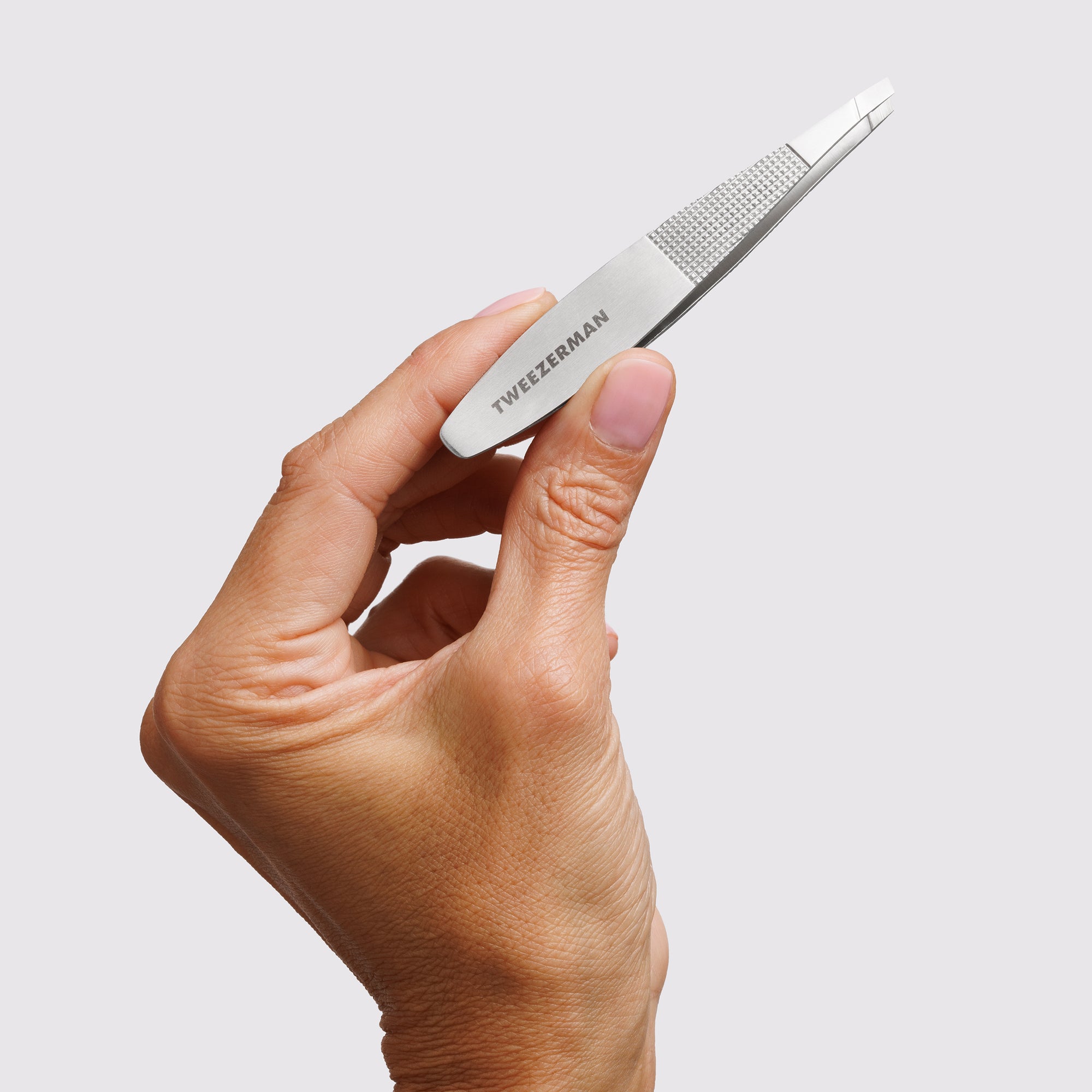 Model holding the Wide Grip Slant Tweezer